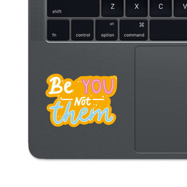 A sticker with the words "Be you not them".